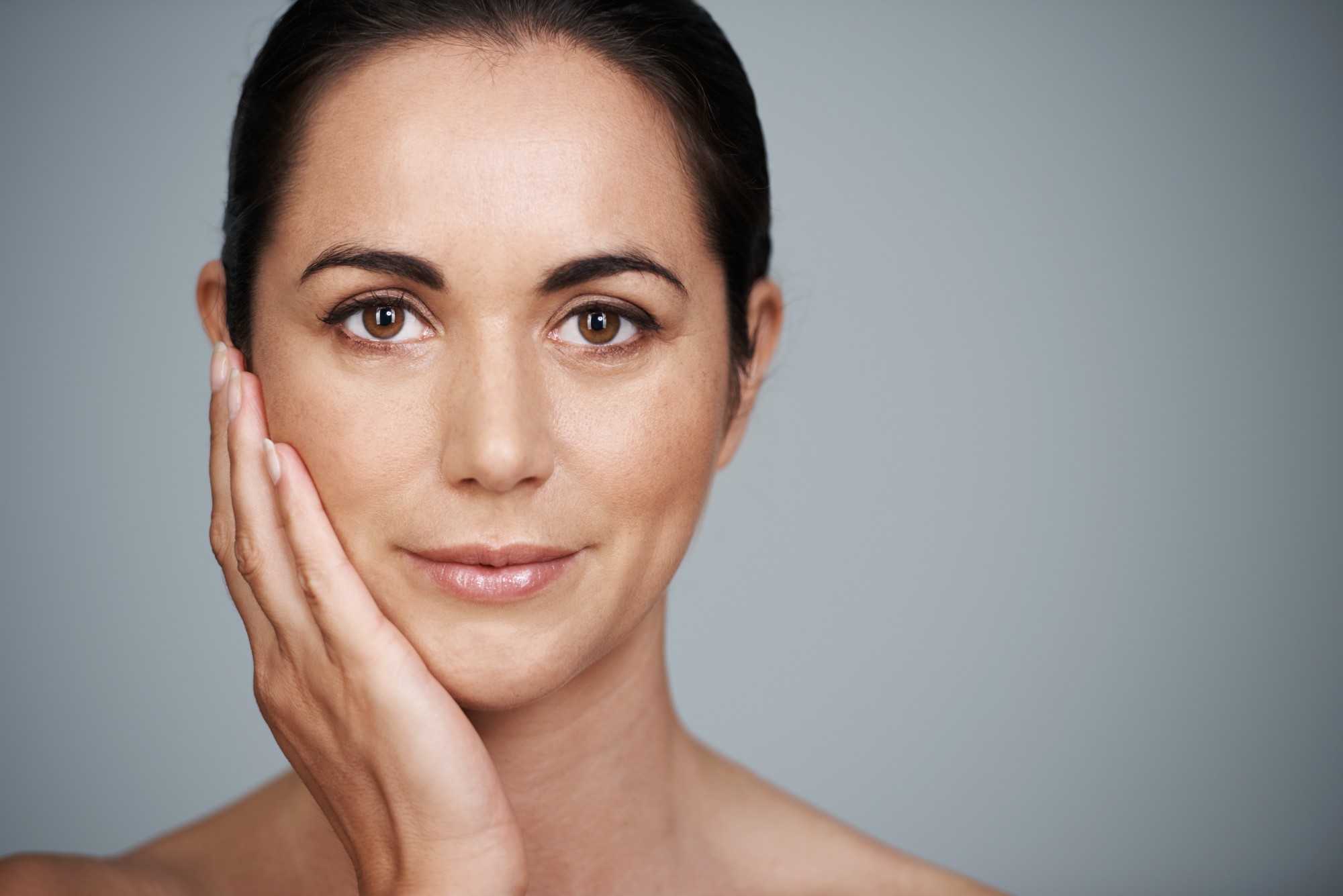 Mujer de cabello oscuro con piel luminosa y expresión natural